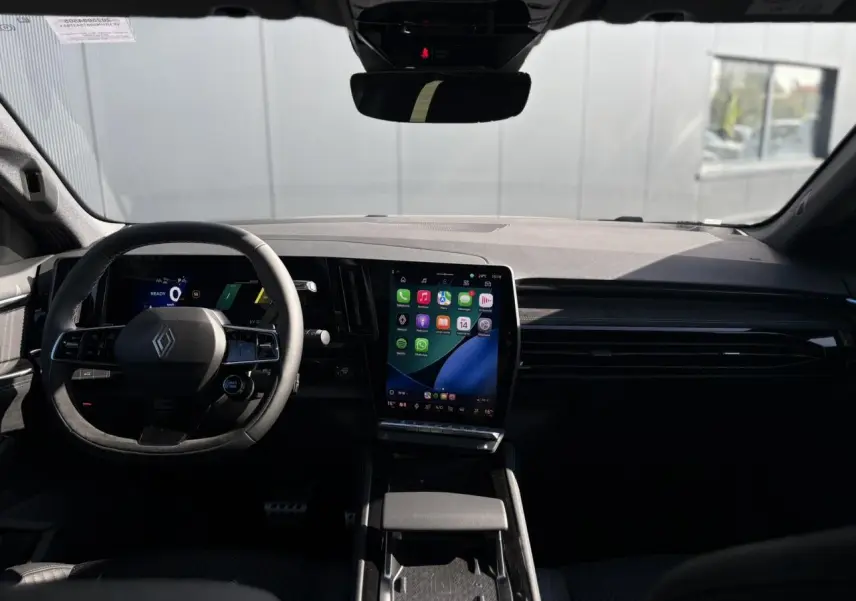 Vue intérieure du tableau de bord du Renault Austral gris Schiste, avec écran tactile vertical et volant multifonction.