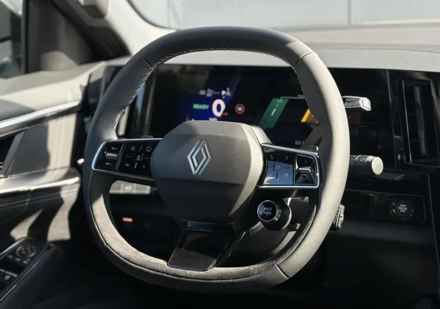 Volant textile Alcantara avec logo Renault, cadrans numériques et commandes intégrées, intérieur noir du Renault Austral E-Tech.