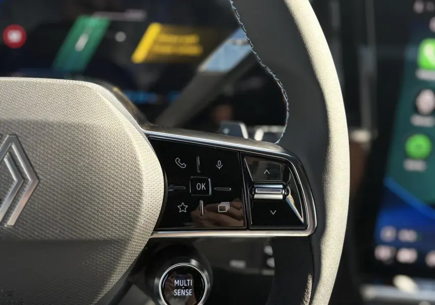 Gros plan sur le volant Alcantara du Renault Austral E-Tech gris, avec commandes multifonctions et bouton Multi Sense.