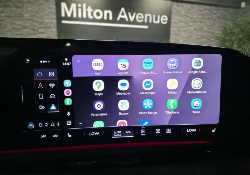 Écran tactile MMI large de l'Audi A5 Avant 2025 affichant des applications connectées avec éclairage d'ambiance rouge.