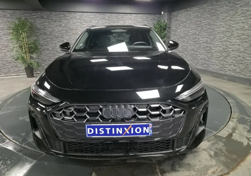 Vue frontale d'une Audi A5 Avant S line noire, mettant en valeur sa calandre hexagonale et ses phares LED fins.