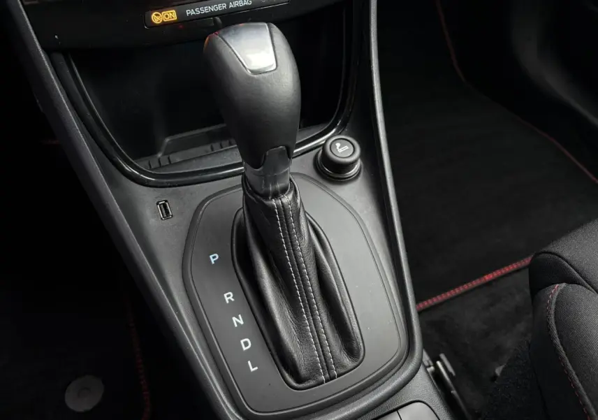 Gros plan sur la commande de boîte automatique noire avec coutures blanches dans l’habitacle du Ford Puma 2024.