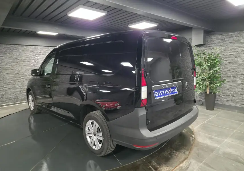 Vue 3/4 arrière droite d'un Volkswagen Caddy Cargo noir avec portes arrière battantes et jantes acier.