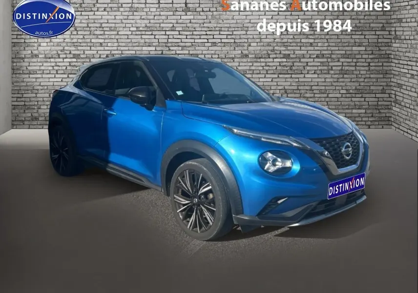 Nissan Juke bleu clair en 3/4 avant droit, avec jantes noires et calandre distinctive V-Motion.