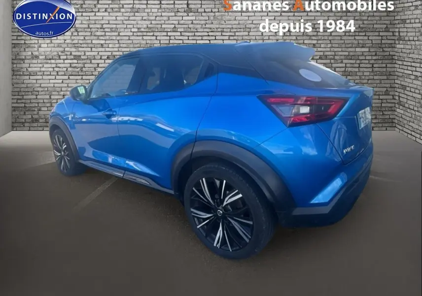 Vue 3/4 arrière droite d'un Nissan Juke bleu clair métallisé, soulignant ses jantes noires à motifs argentés.