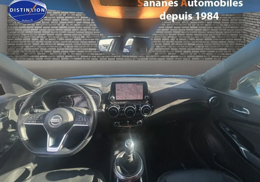 Vue intérieure avant du Nissan Juke 2020, tableau de bord noir avec écran tactile et volant multifonctions.