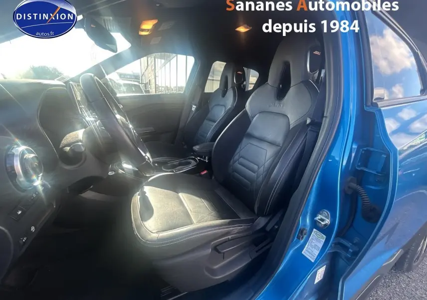 Vue intérieure côté conducteur du Nissan Juke bleu clair 2020, mettant en valeur les sièges en cuir noirs et le volant.