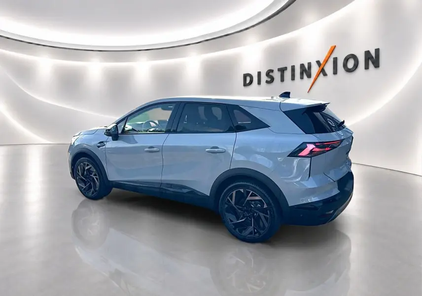 Renault Symbioz gris rafale en vue 3/4 arrière droit, avec jantes noires et feux arrière LED distinctifs.