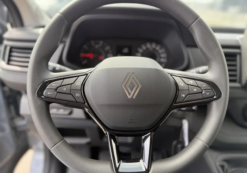 Vue rapprochée du volant multifonction gris du Renault Trafic Combi L2 Grand Evolution 2025 avec commandes intégrées.