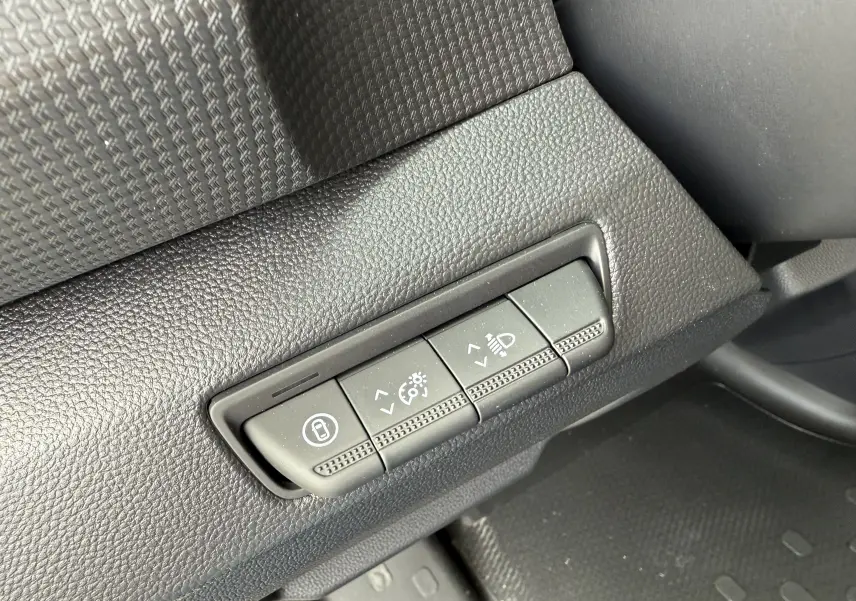 Gros plan sur les commandes de réglage du tableau de bord du Renault Trafic Combi gris, côté gauche conducteur.