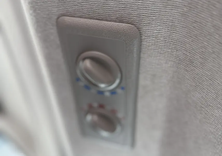 Gros plan sur les commandes de climatisation intégrées au plafond du Renault Trafic Combi gris Urban, intérieur tissu.