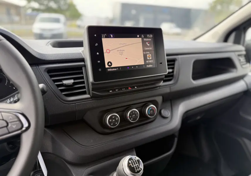 Tableau de bord du Renault Trafic Combi 2025 avec écran tactile, commandes climatisation et levier de vitesses manuel visible côté conducteur.
