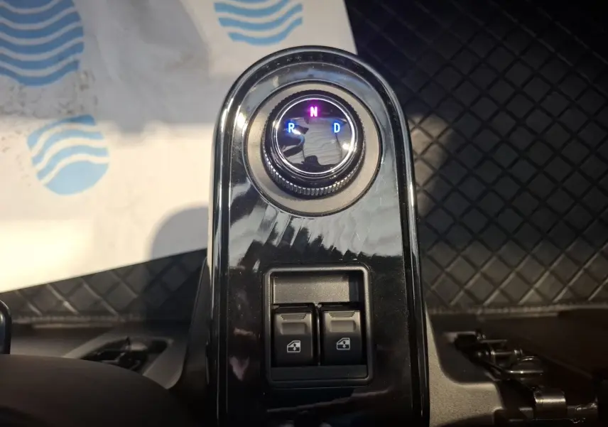 Gros plan sur la commande de boîte automatique et les boutons de lève-vitres dans l’habitacle du Simplici S1 gris perle.