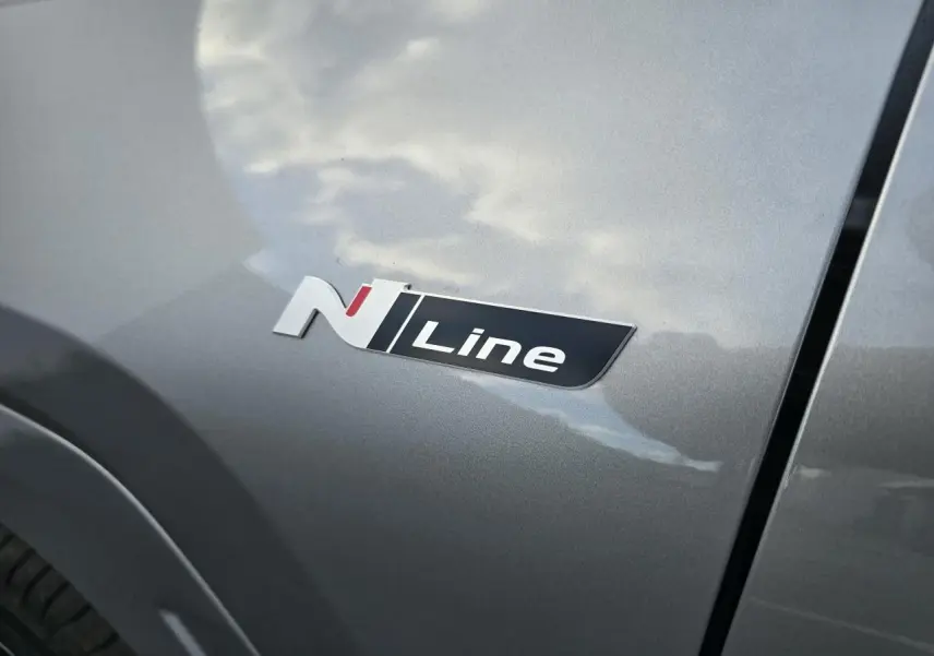 Gros plan sur l'emblème N Line sur la portière côté gauche d'un Hyundai Tucson 2025 couleur argent métallisé.