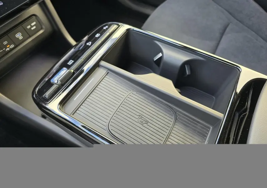 Vue rapprochée de la console centrale noire du Hyundai Tucson 2025, avec porte-gobelets et commandes de boîte auto.