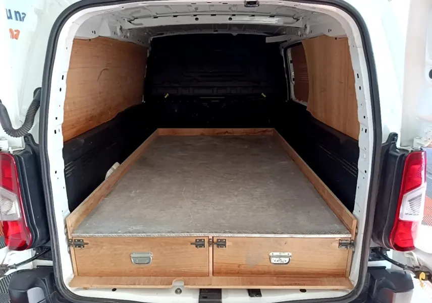 Vue arrière du Peugeot Partner blanc 2021 avec espace de chargement aménagé en bois et surface plane.