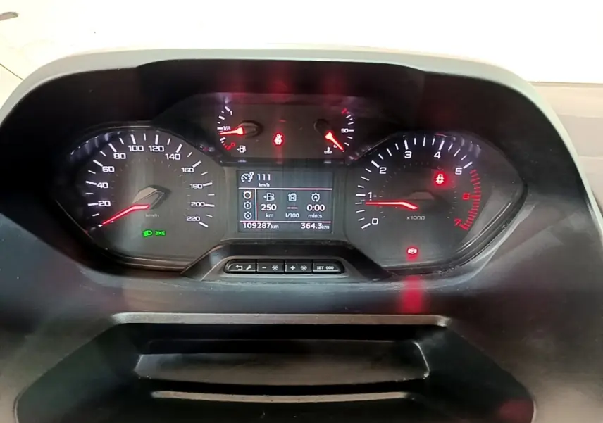 Vue rapprochée du tableau de bord numérique du Peugeot Partner 2021, affichant vitesse, compte-tours et informations de conduite.