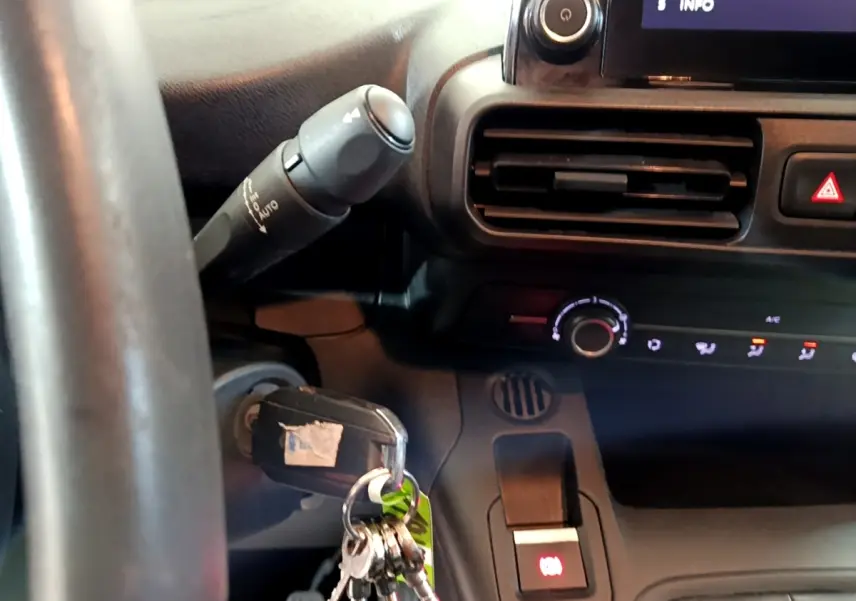 Gros plan sur le tableau de bord et volant noir du Peugeot Partner 2021 avec clé insérée dans le contacteur.