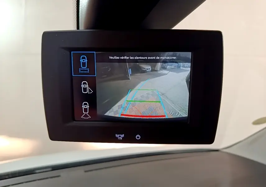 Écran tactile intérieur montrant la caméra de recul du Peugeot Partner blanc, vue depuis le tableau de bord.