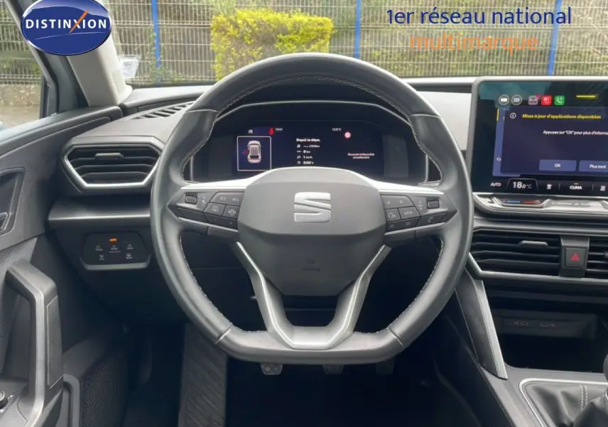 Vue intérieure centrée sur le volant cuir multifonction et tableau de bord numérique de la SEAT LEON 2.0 TDI blanc neige métal.