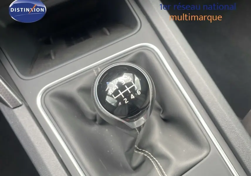 Gros plan sur le levier de vitesse manuel de la SEAT LEON 2.0 TDI, entouré d’un soufflet en cuir noir.
