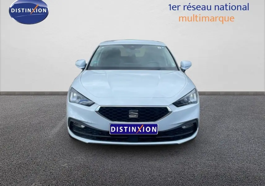 Vue frontale d'une SEAT Leon 2025 blanc neige métal avec calandre hexagonale et phares LED marqués.
