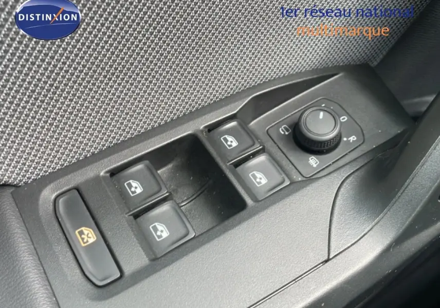 Gros plan sur les commandes des vitres et des rétroviseurs côté conducteur d'une SEAT LEON blanc neige métal.