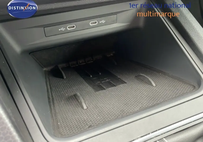 Vue rapprochée de la console centrale du SEAT LEON 2025, avec prise USB et tapis antidérapant noir.