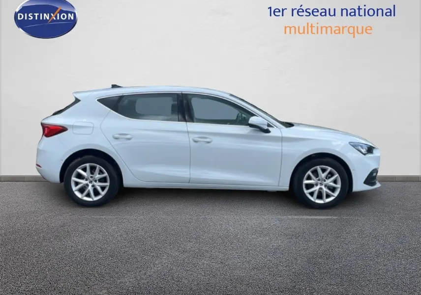 Vue latérale droite d'une SEAT Leon blanche neige métal 2025, avec jantes alliage et lignes épurées.