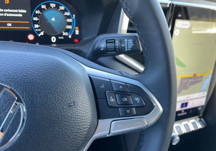 Gros plan sur le volant cuir multifonctions côté droit du Volkswagen Amarok 2026 avec tableau de bord digital et écran GPS.