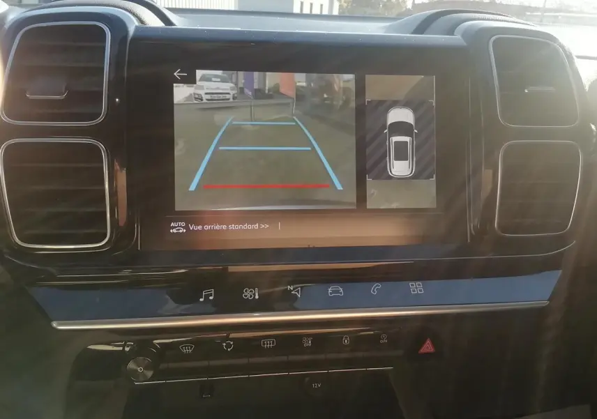 Vue intérieure du tableau de bord du Citroën C5 Aircross gris, écran tactile affichant la caméra de recul et l'aide au stationnement.