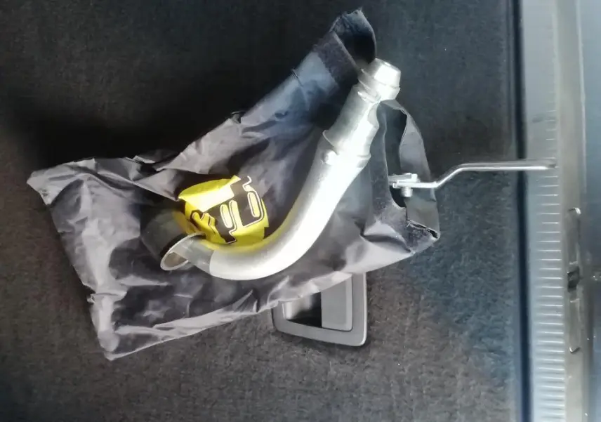 Gros plan sur l'attelage col de cygne démontable posé dans le coffre d'un Citroën C5 Aircross gris.