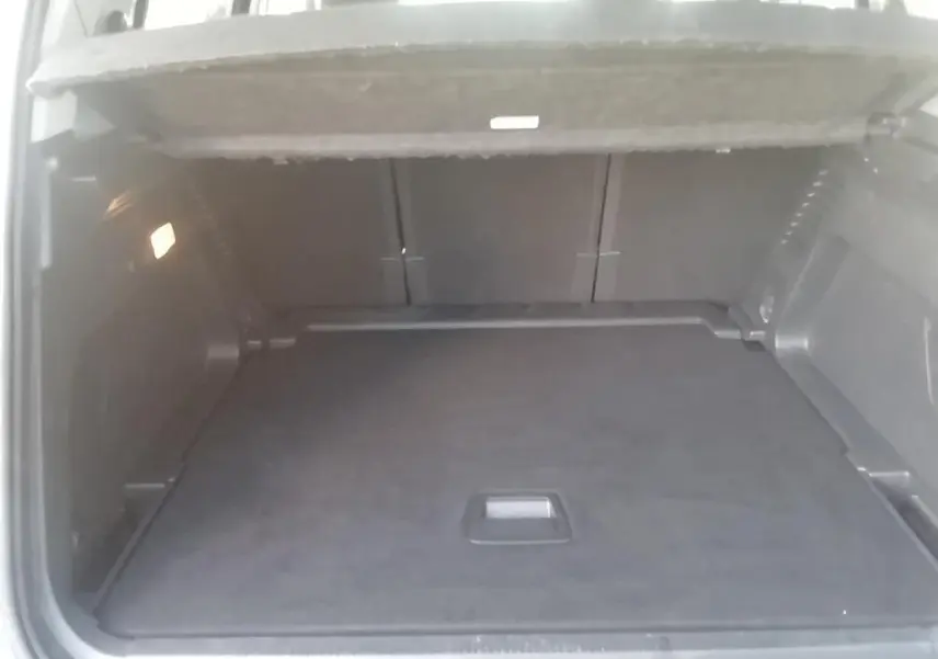Vue intérieure du coffre spacieux et propre du Citroën C5 Aircross gris, avec plancher plat et éclairage latéral.