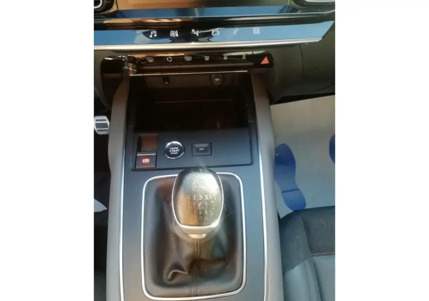 Vue plongeante sur la console centrale du Citroën C5 Aircross gris, mettant en valeur le levier de vitesse manuel et les commandes environnantes.
