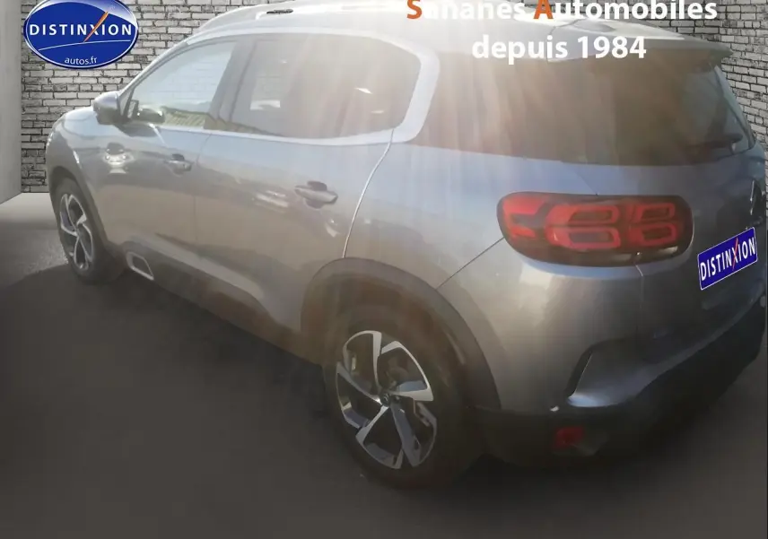 Vue 3/4 arrière droite d'un Citroën C5 Aircross gris métallisé avec jantes alliage 18 pouces et feux arrière LED.