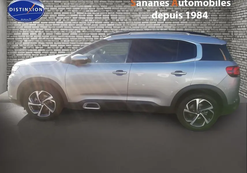 Profil droit d’un Citroën C5 Aircross gris métallisé 2019 avec jantes alliage et barres de toit bi-ton.