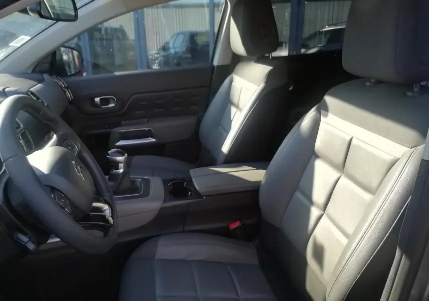 Vue intérieure côté conducteur du Citroën C5 Aircross gris, montrant sièges Advanced Comfort et levier de vitesses manuel.