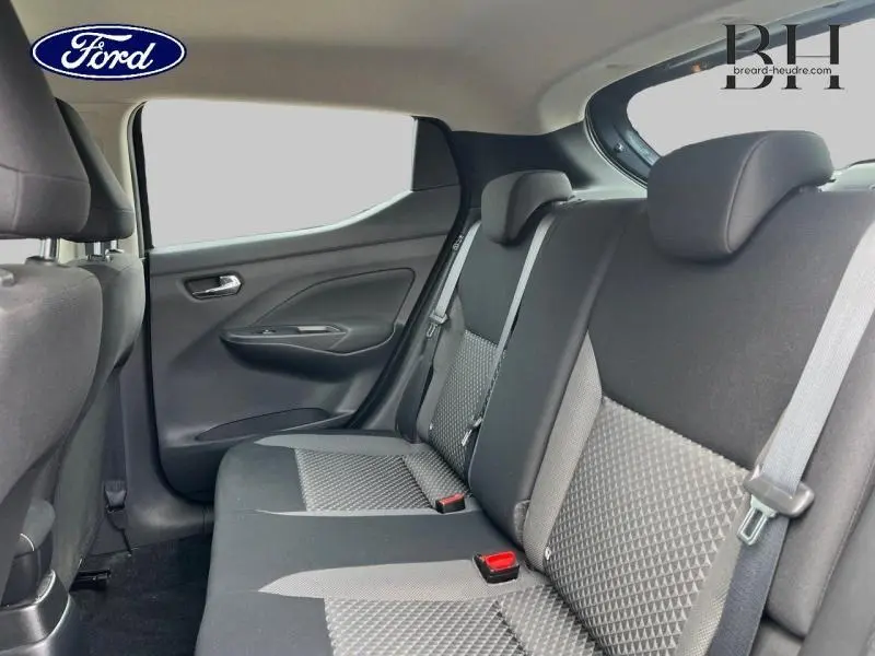 Vue intérieure arrière des sièges en tissu bi-ton noir et gris d'une Nissan Micra Gris Acier 2022, avec ceintures de sécurité visibles.