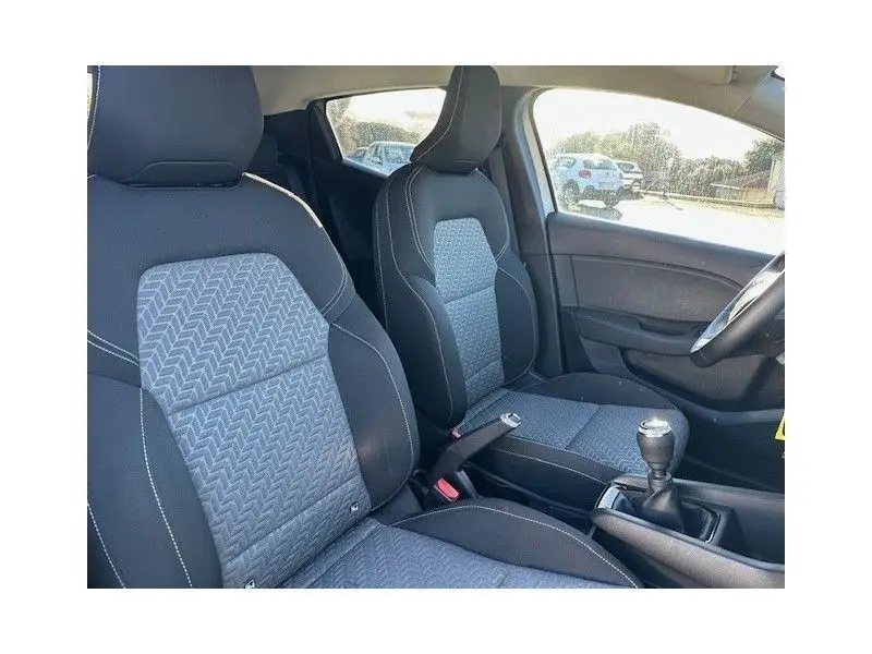 Intérieur avant de la Renault Clio V gris schiste, sièges tissu bi-matière avec motifs géométriques et levier de vitesse manuel.