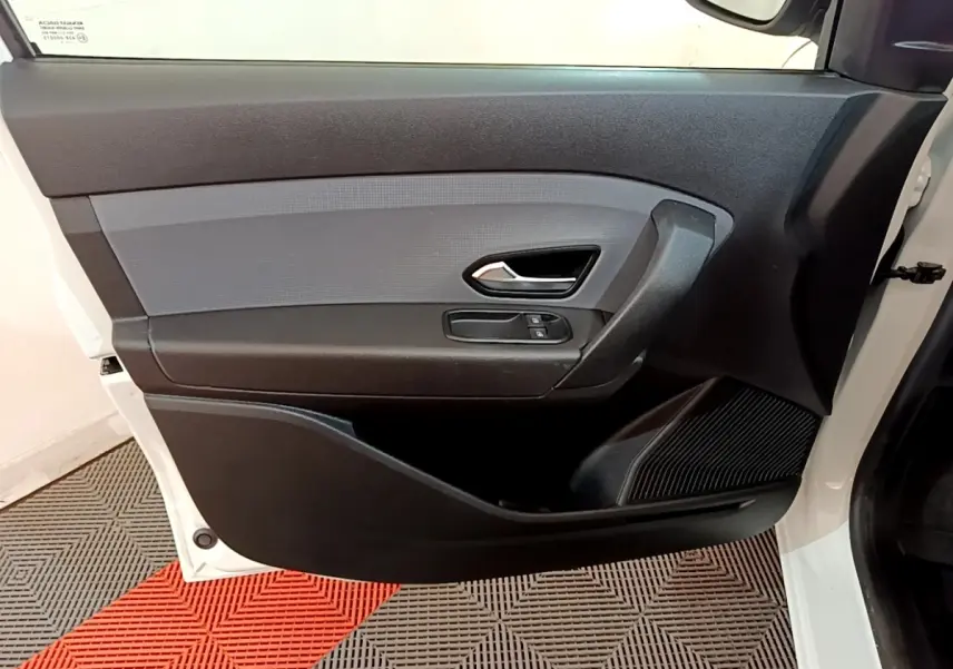 Vue intérieure de la porte avant droite noire et grise du Renault Express blanc, avec poignée et commandes de vitres.