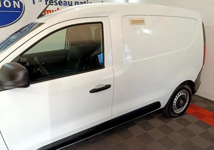 Vue de profil côté gauche d’un utilitaire Renault Express blanc avec porte latérale pleine et rétroviseur noir.