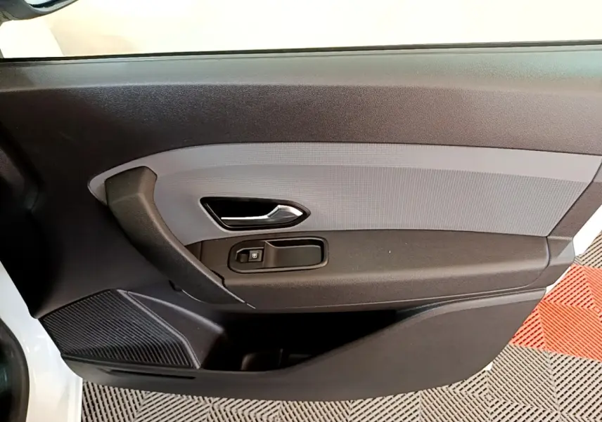 Vue rapprochée de la porte intérieure côté conducteur du Renault Express blanc, avec poignée et commande de vitre noire.