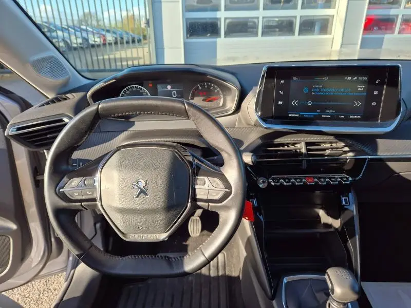 Vue intérieure centrée sur le volant compact et le tableau de bord numérique de la Peugeot 208 gris Artense 2020.