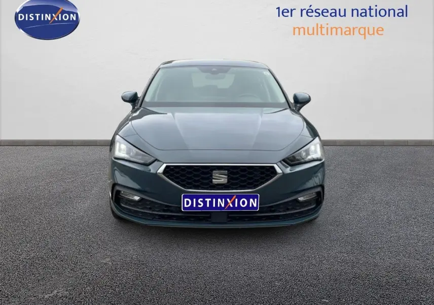 Vue frontale d'une SEAT LEON 2.0 TDI 115CH STYLE XL en bleu fjord avec calandre hexagonale et phares LED allumés.