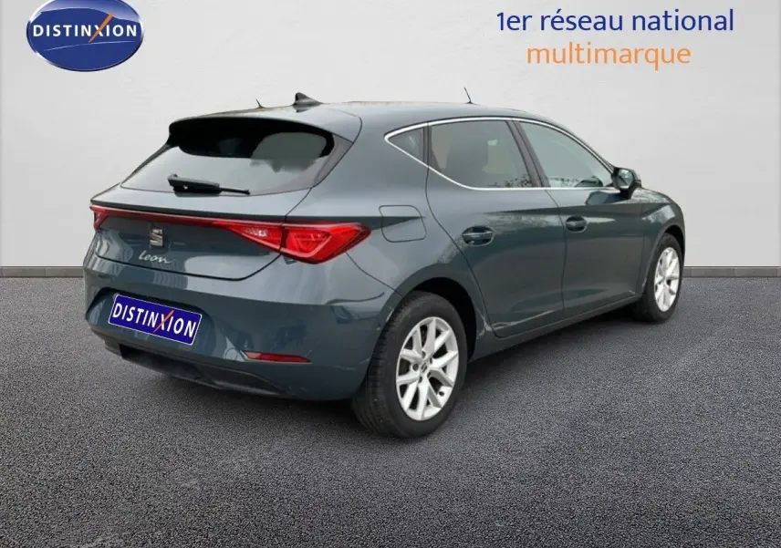 SEAT Leon bleu fjord vue 3/4 arrière droit, hayon et feux arrière distinctifs, jantes alliage argentées.