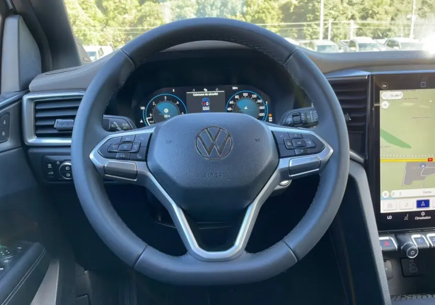 Volant cuir multifonctions Volkswagen Amarok V6 240 2026 vu de face avec tableau de bord digital et écran GPS tactile.