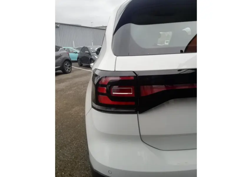 Vue arrière gauche d'un Volkswagen T-Cross blanc 2020 avec feux arrière LED et lunette teintée.