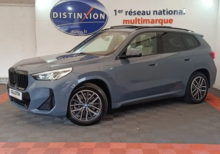 BMW X1 xDrive25e M Sport gris foncé vue de profil droit en intérieur avec jantes alliage et toit noir.