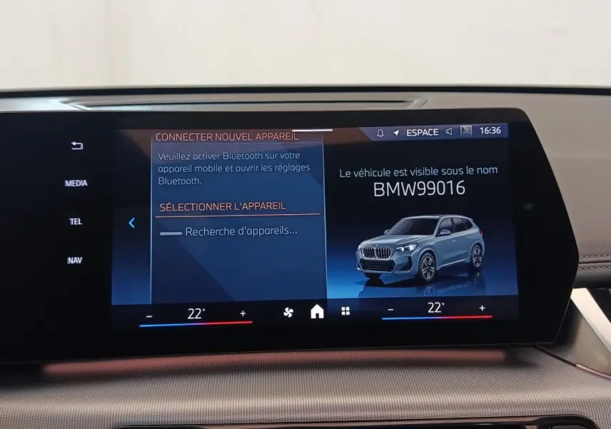 Écran tactile central affichant un BMW X1 gris foncé en 3/4 avant droit dans l'interface multimédia.