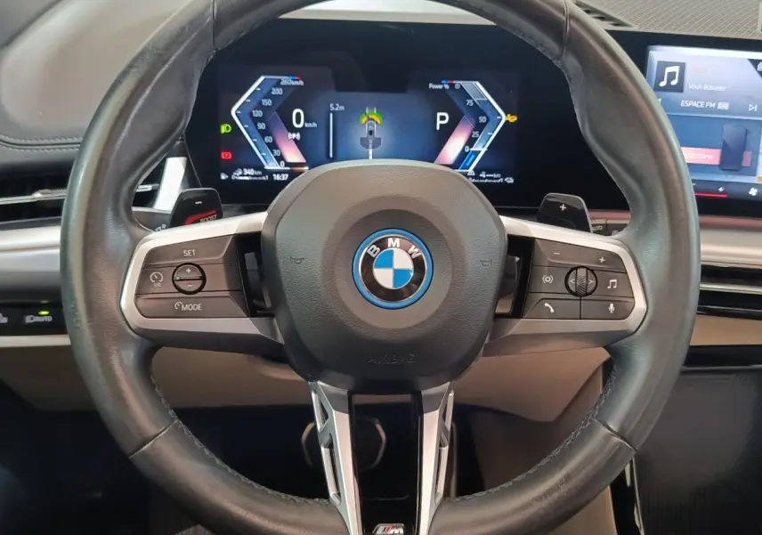 Vue rapprochée du volant cuir M Sport et du combiné numérique 10,25 pouces du BMW X1 xDrive25e gris foncé 2024.